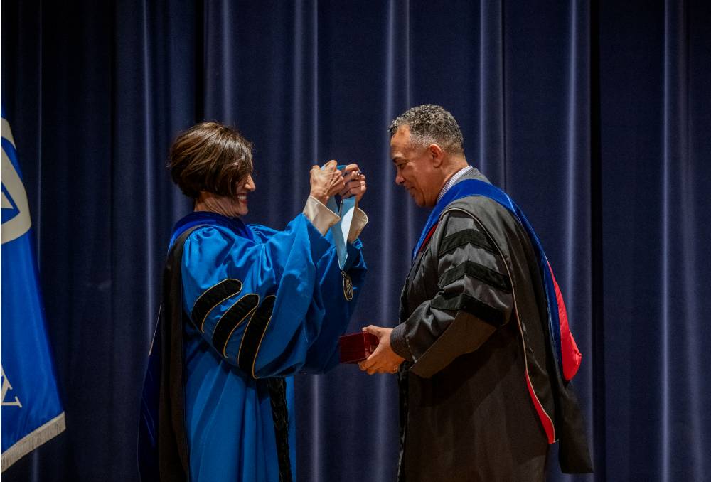 Provost giving a medallion to a faculty member
